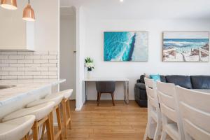 a kitchen and dining room with a table and chairs at 'Sandy Shores' A Spacious Newcastle Beach Escape in Newcastle