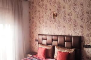 sypialnia z łóżkiem z czerwonymi poduszkami w obiekcie Chez Noufissa w Marakeszu