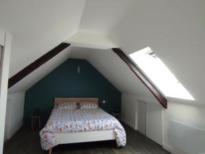 um quarto com uma cama com uma parede verde em Le gîte de ty stumo1 em Neulliac