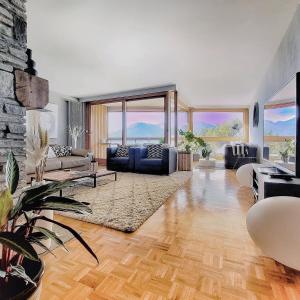 a living room with a couch and chairs and a fireplace at L'AvantGardiste, Spacious 6 bedrooms duplex, panoramic view in Crans-Montana