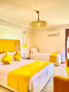 Habitación de hotel con 2 camas y lámpara de araña. en Riad Al Wafaa, en Marrakech