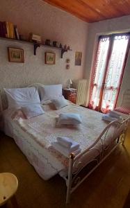 a bedroom with a large bed with two windows at Appartamento panoramico Casa Gerro in Averara