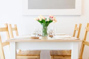 a table with a vase of flowers on it at Apartment Harmonia Oliwska by Renters in Gdańsk
