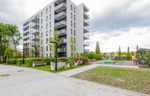 an apartment building with a park in front of it at Apartment Harmonia Oliwska by Renters in Gdańsk