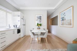 a kitchen and dining room with a table and chairs at Local's Corner - Boutique Living by Bondi Beach in Sydney