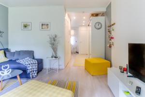 sala de estar con sofá azul y taburete amarillo en Holiday Apartment Usva Studio C 7, en Kemijärvi
