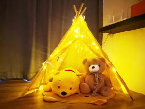 deux ours en peluche assis sur le sol sous une tente dans l'établissement Hanns&FreeWIFI&Washer+Pool@SunshineComfortHMStay3, à Sibu