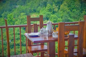 einen Tisch auf dem Balkon mit Speisen und Getränken darauf in der Unterkunft Rock Edge Residence in Kandy