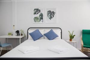 um quarto com uma cama branca e almofadas azuis em Loft-Style Living - Sophisticated Urban Retreat em Sydney