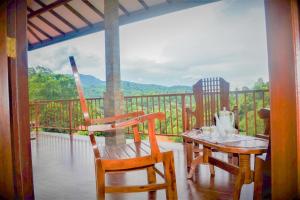 einen Tisch und Stühle auf einem Balkon mit Aussicht in der Unterkunft Rock Edge Residence in Kandy