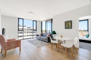 a living room with a table and chairs and a couch at Bright Rockdale Escape near Bayside Beaches in Sydney