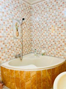 a bath tub in a bathroom with tiles at Duvha Guesthouse in Graskop