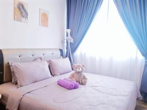 a teddy bear sitting on top of a bed at Hanns&FreeWIFI&Washer+Pool@SunshineComfortHMStay3 in Sibu