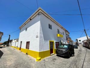 Casa das Memórias : سيارة متوقفة أمام مبنى أبيض وأصفر