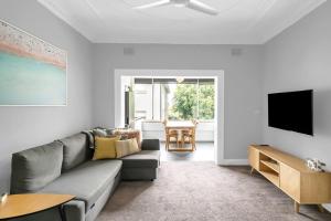 een woonkamer met een bank en een flatscreen-tv bij 'Beachside Bliss' Heart of the Coastal Lifestyle in Sydney