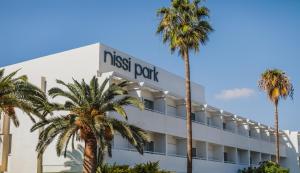 a hotel with palm trees in front of it at Nissi Park Hotel in Ayia Napa