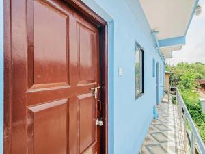 a red door of a blue building with a staircase at OYO Hotel 49339 On The Rocks in Arambol