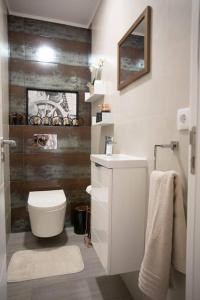 a white bathroom with a toilet and a sink at Apartamento Janelas da Ria in Faro