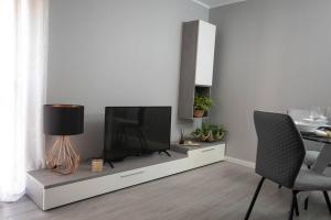 a living room with a tv and a table with chairs at Apartamento Janelas da Ria in Faro