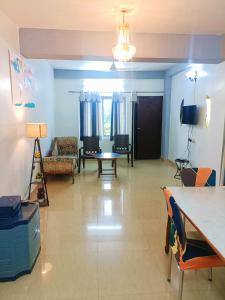a living room with blue walls and a table and chairs at Pretty Garden View Apartment 3BHK Furnished Flat near Kashi Vishwanath Temple in Varanasi