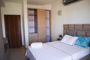 a bedroom with a white bed with a wooden headboard at Omas Ocean in Porlamar