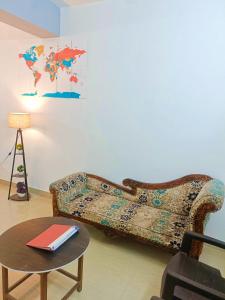 a couch sitting in a living room with a table at Pretty Garden View Apartment 3BHK Furnished Flat near Kashi Vishwanath Temple in Varanasi