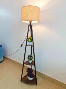 a floor lamp with two potted plants on it at Pretty Garden View Apartment 3BHK Furnished Flat near Kashi Vishwanath Temple in Varanasi