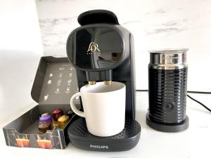 a coffee maker with a cup and a coffee mug at Beautiful 3-bed apartment at Swiss Cottage in London
