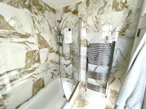 a shower with a glass door in a bathroom at Beautiful 3-bed apartment at Swiss Cottage in London