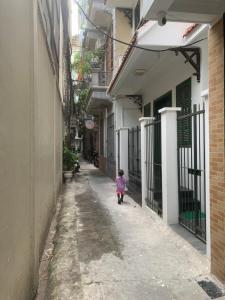 a little girl walking down a alley way at Rainbow HomeStay - No 8 Alley 18B Tong Dan in Hanoi