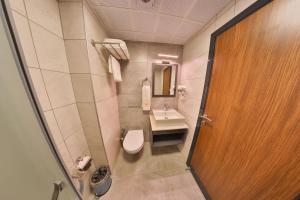 a bathroom with a toilet and a sink and a door at BUKAVİYYE HOTEL in Ankara
