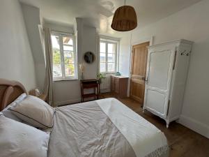 een slaapkamer met een wit bed en een raam bij Gîte « Le Marie » in Saint-Martin-aux-Buneaux