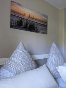 ein Bett mit zwei Kissen und einem Bild an der Wand in der Unterkunft Ferienwohnung Aus-Zeit auf dem Lande in Bad Gottleuba