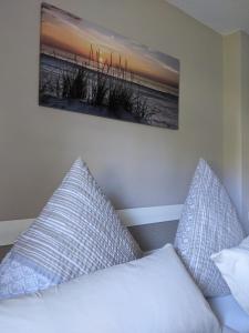 a bed with two pillows and a picture on the wall at Ferienwohnung Aus-Zeit auf dem Lande in Bad Gottleuba