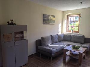 a living room with a couch and a table at Ferienwohnung Aus-Zeit auf dem Lande in Bad Gottleuba