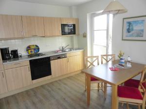 eine Küche mit Holzschränken, einem Tisch und einem Esszimmer in der Unterkunft Ferienwohnung 3 26 Inselstrand in Ahlbeck