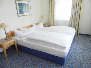 ein Schlafzimmer mit einem großen Bett mit weißen Laken und Kissen in der Unterkunft Ferienwohnung 3 26 Inselstrand in Ahlbeck