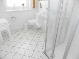 ein weißes Badezimmer mit Toilette und Dusche in der Unterkunft Ferienwohnung 3 26 Inselstrand in Ahlbeck + 7 Fotos