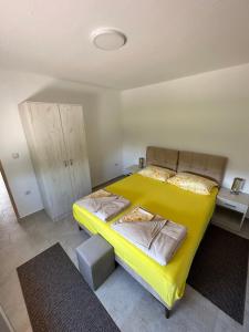 Apartman Sofija HN في هرسك نوفي: سرير اصفر في غرفة صغيرة ذات فرش اصفر