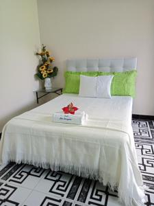 Un dormitorio con una cama blanca con una caja. en Hotel Alto Amazonas en Leticia