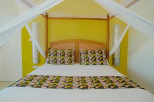 Bett mit einem Kopfteil aus Holz in einem Zimmer in der Unterkunft Villa Citrus Zanzibar in Jambiani