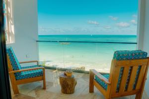 - une chambre avec deux chaises et une vue sur la plage dans l'établissement Villa Citrus Zanzibar, à Jambiani