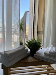 a pile of towels sitting on a table in front of a window at B&B D'Aponte Home in Volla