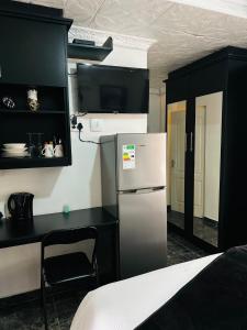 een keuken met een koelkast en een tafel in een kamer bij Duvha Guesthouse in Graskop