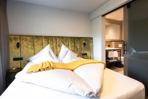 una camera da letto con un letto bianco con cuscini bianchi di Apart Sailers a Sankt Anton am Arlberg