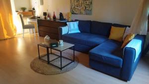 sala de estar con sofá azul y mesa en A L ESCALE PASSA PAÏS, en Le Poujol-sur-Orb