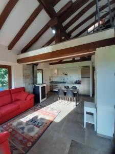 ein Wohnzimmer mit einem roten Sofa und einer Küche in der Unterkunft Tranquillità e Relax in Villeneuve