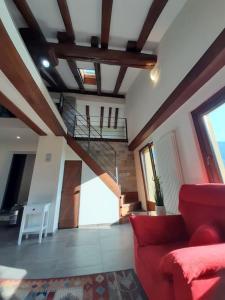 uma sala de estar com um sofá vermelho e uma escada em Tranquillità e Relax em Villeneuve