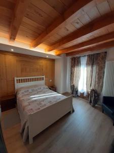 um quarto com uma cama grande e um tecto de madeira em Tranquillità e Relax em Villeneuve