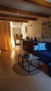 Sala de estar con sofá azul y mesa de centro en A L ESCALE PASSA PAÏS, en Le Poujol-sur-Orb